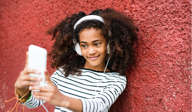 Girl using iPhone with Headphones on